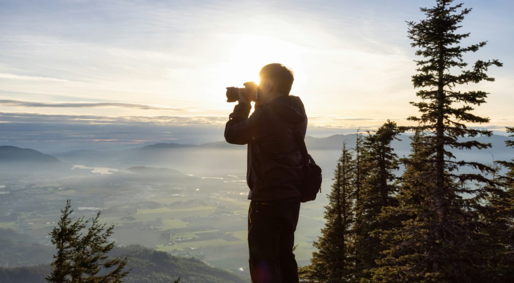 Adventure Photographer taking pictures while Hiking in Canadian Nature